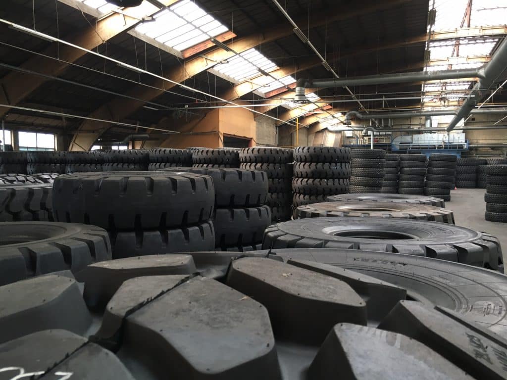 Neumáticos para movimiento de tierras y camiones apilados en un almacén